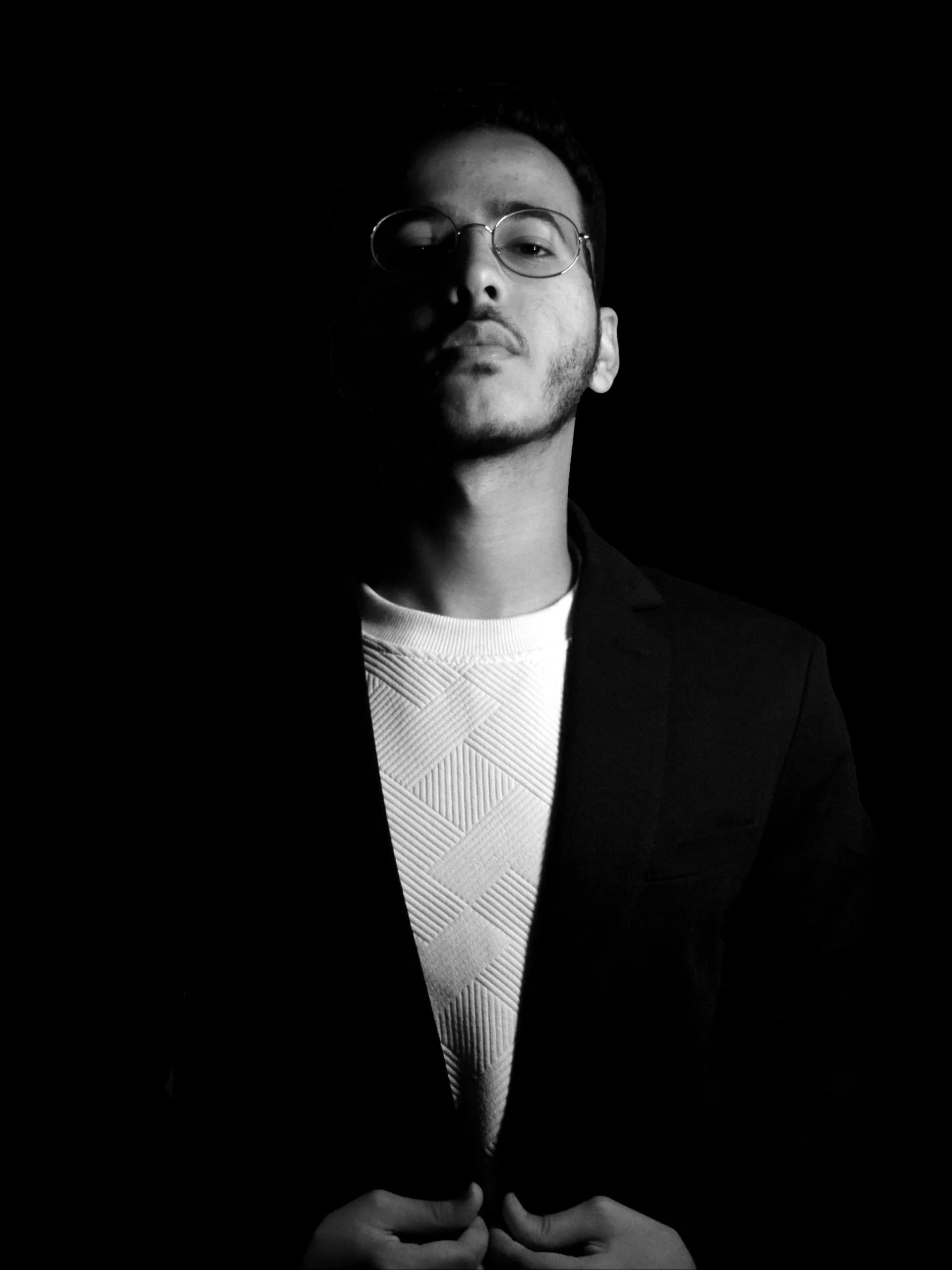 Amr Mosallem, lit from one side against black.